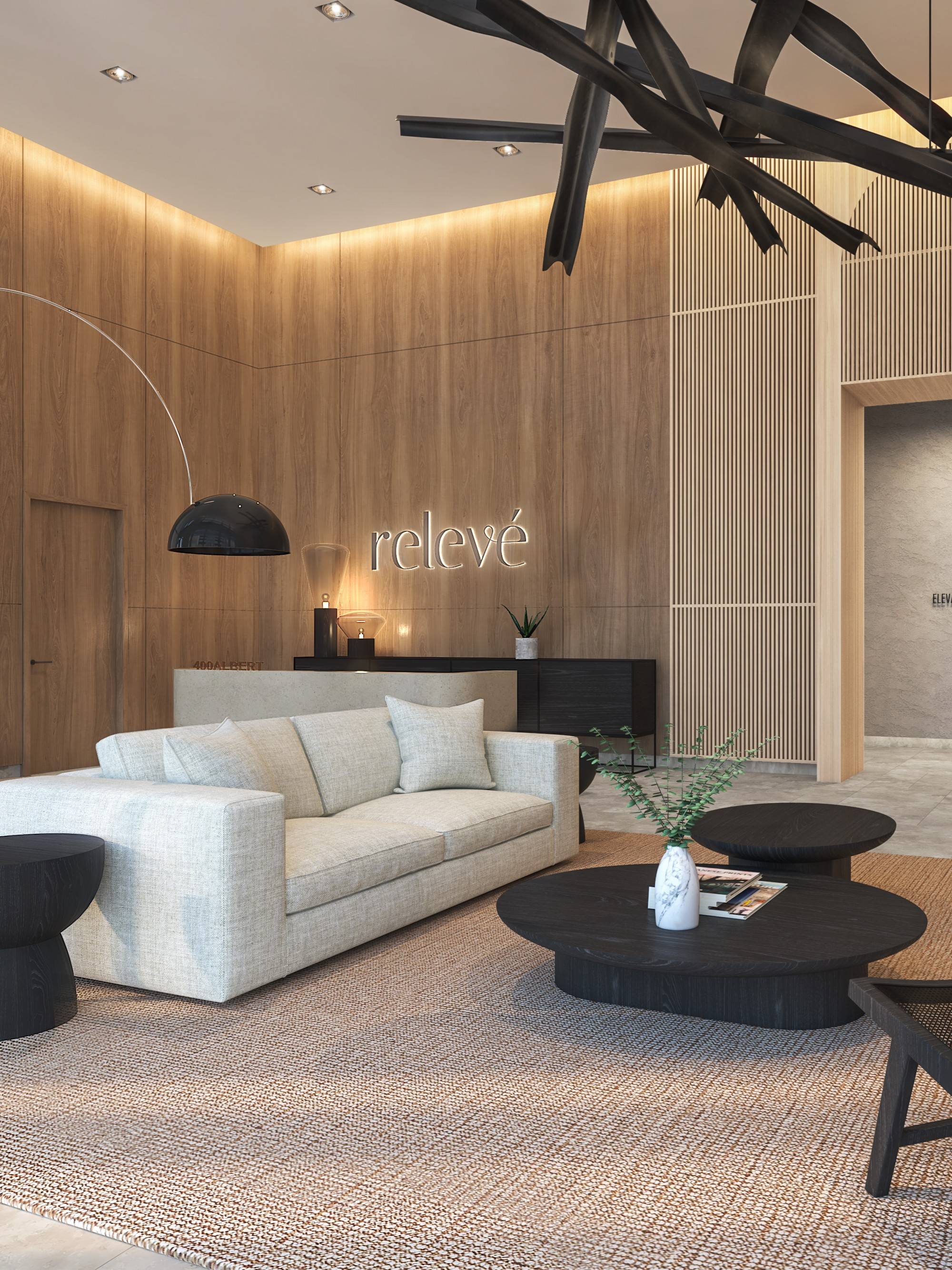 Relevé lobby featuring a couch, coffee table, fireplace, and a large painting, creating a welcoming atmosphere.